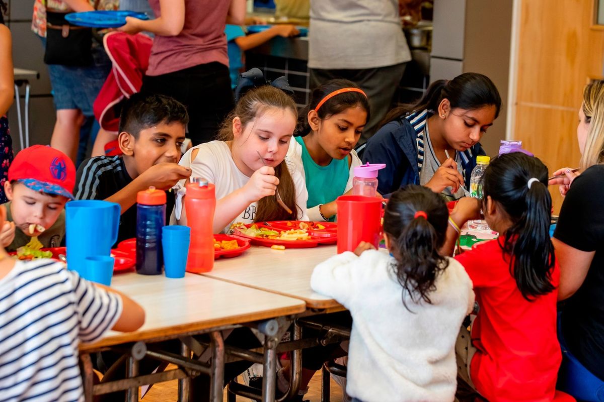 Children having meals together during holiday food support programme